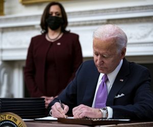 epa08956640 US President Joe Biden signs an executive order after speaking during an event on his administration's Covid-19 response with U.S. Vice President Kamala Harris, left, in the State Dining Room of the White House in Washington, DC, USA, on 21 January 2021. Biden in his first full day in office plans to issue a sweeping set of executive orders to tackle the raging Covid-19 pandemic to rapidly reverse or refashion many of his predecessor's most heavily criticized policies.  EPA/Al Drago / POOL