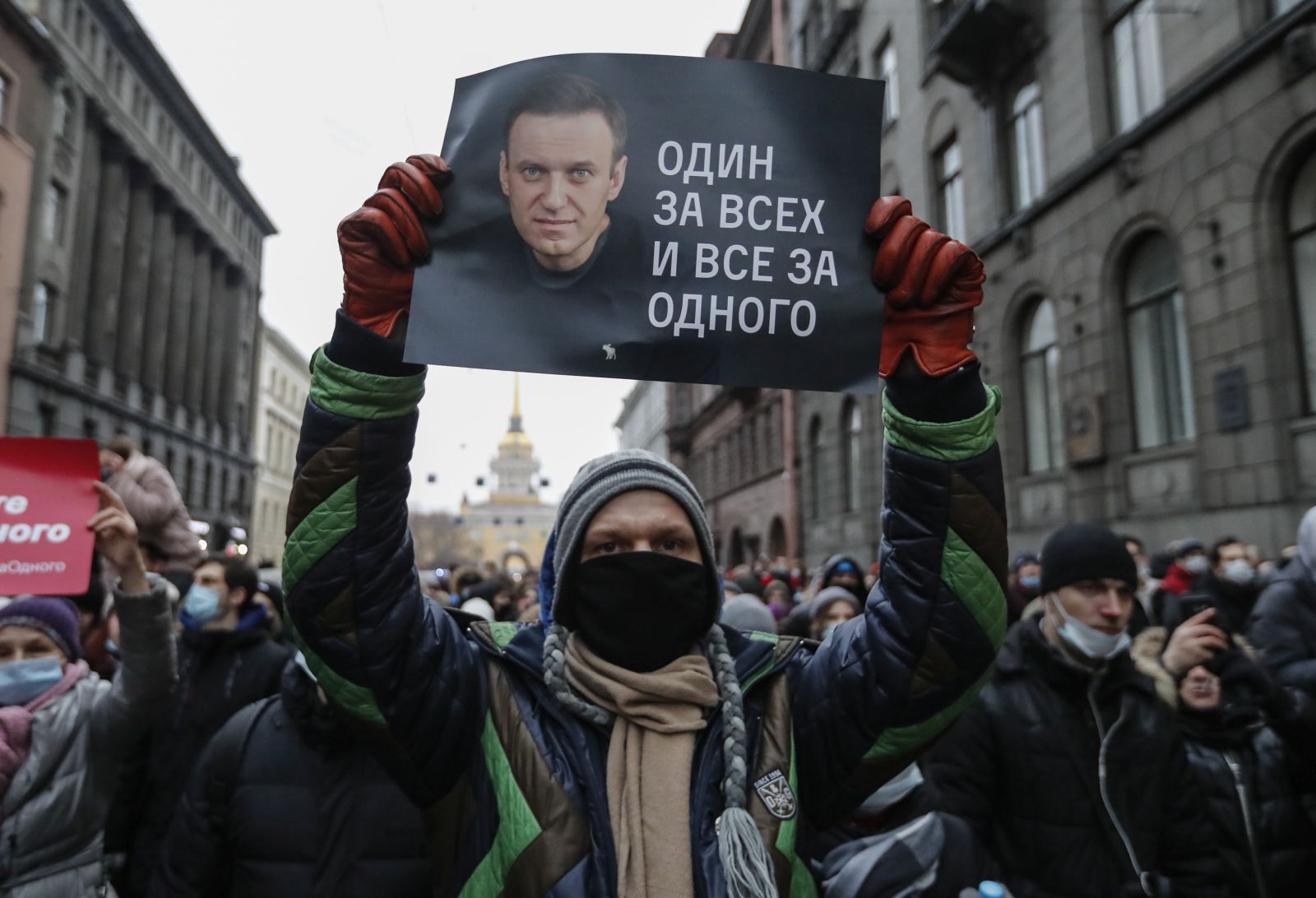 epa08959951 A protester holds a poster that reads 'One for all and all for one', during an unauthorized protest in support of Russian opposition leader and blogger Alexei Navalny, in St. Petersburg, Russia, 23 January 2021. Navalny was detained after his arrival to Moscow from Germany on 17 January 2021. A Moscow judge on 18 January ruled that he will remain in custody for 30 days following his airport arrest. Navalny urged Russians to take to the streets to protest. In many Russian cities mass events are prohibited due to an increasing number of cases of the COVID-19 pandemic caused by the SARS CoV-2 coronavirus.  EPA/ANATOLY MALTSEV
