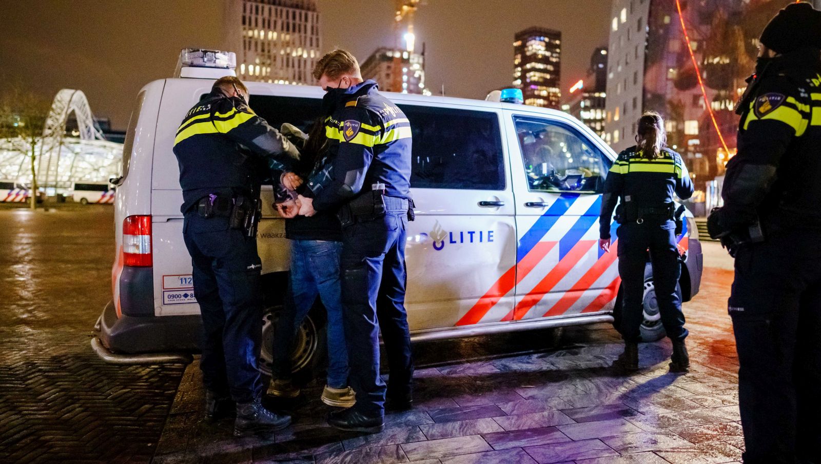 epa08961340 A man is arrested by the police after a protest against the curfew on the Binnenrotte near the Markthal in Rotterdam, The Netherlands, 23 January 2021. Due to the Covid-19 pandemic, there is a curfew throughout the Netherlands from 23 January and lasts from 9:00 PM to 4:30 AM.  EPA/MARCO DE SWART