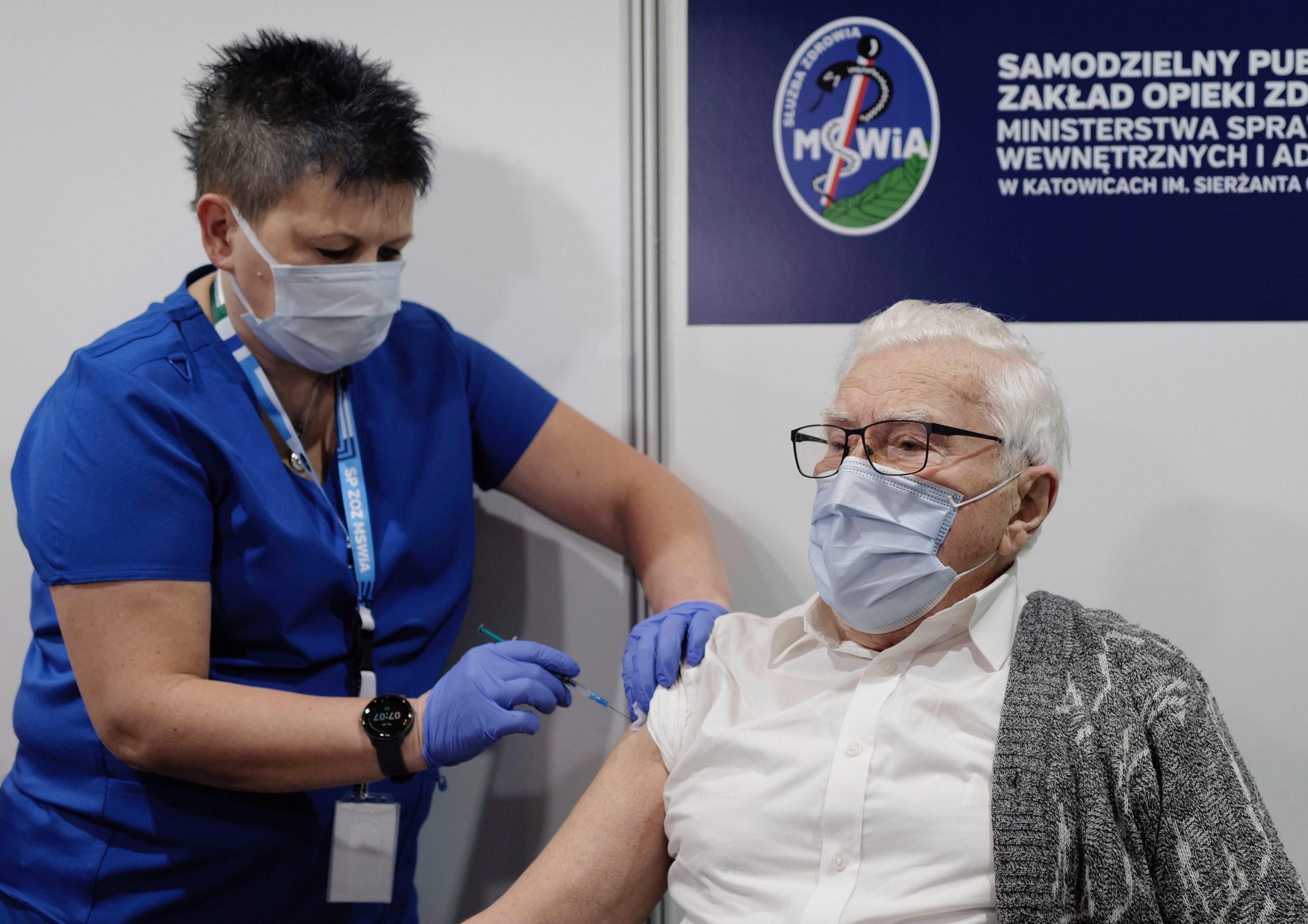 epa08963598 Wlodzimierz Czechowski (R) is the first senior in Poland to be vaccinated against the COVID-19, in a temporary hospital at the International Congress Center in Katowice, Poland, 25 January 2021. Vaccination for seniors against the coronavirus disease (COVID-19) has started across the country.  EPA/ANDRZEJ GRYGIEL POLAND OUT