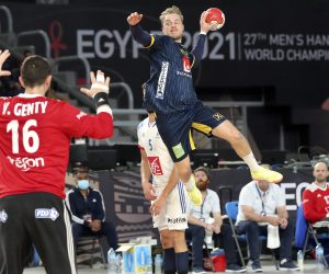 epa08973574 Sweden’s Daniel Pettersson (R) in action against France's goalkeeper Yann Genty (L) during the semi final match between France and Sweden at the 27th Men's Handball World Championship in Cairo, Egypt, 29 January 2021.  EPA/KHALED ELFIQI