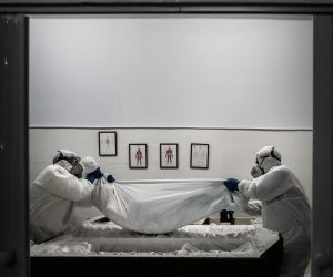epa08976010 Funerary workers wearing protective suits hold the body of a woman, who died of Covid-19, in Amadora, outskirts of Lisbon, Portugal, 29 January 2021 (issued on 30 January 2021). This week Portugal surpassed 300 covid-19 deaths in a single day, a new maximum of deaths since the beginning of the pandemic. Portuguese government imposed a 14-day national lockdown including foreign travel restrictions, as the country is fighting the surge of new variant of coronavirus Covid-19 that puts the health care system under severe pressure.  EPA/MARIO CRUZ  ATTENTION: This Image is part of a PHOTO SET