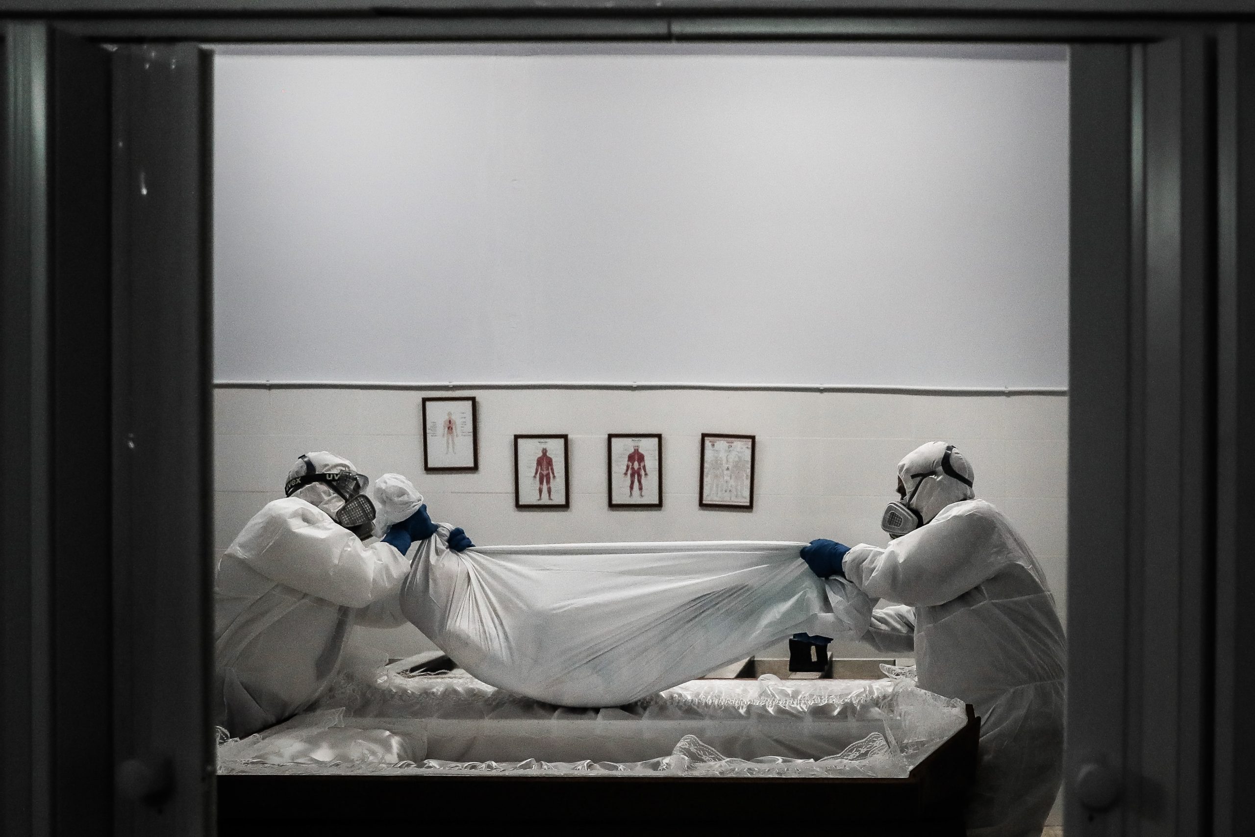 epa08976010 Funerary workers wearing protective suits hold the body of a woman, who died of Covid-19, in Amadora, outskirts of Lisbon, Portugal, 29 January 2021 (issued on 30 January 2021). This week Portugal surpassed 300 covid-19 deaths in a single day, a new maximum of deaths since the beginning of the pandemic. Portuguese government imposed a 14-day national lockdown including foreign travel restrictions, as the country is fighting the surge of new variant of coronavirus Covid-19 that puts the health care system under severe pressure.  EPA/MARIO CRUZ  ATTENTION: This Image is part of a PHOTO SET