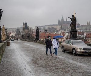 epa08972560 Women walk past a car parked on Charles Bridge in Prague, Czech Republic, 29 January 2021. Two cars and one van, with a sign on its side in a reference to websites, reading in English ''Sorry government'' were parked on Charles Bridge in a protest against the government's new Coronavirus measures.  EPA/MARTIN DIVISEK