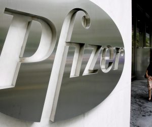 epa08980076 (FILE) - A file image dated 26 June 2006 showing a woman walking past a sign in front of the world headquarters building of Pfizer Inc. in New York, USA (reissued 01 February 2021). Pfizer is due to release its 4th quarter 2020 results on 02 February 2021.  EPA/JUSTIN LANE *** Local Caption *** 52754641