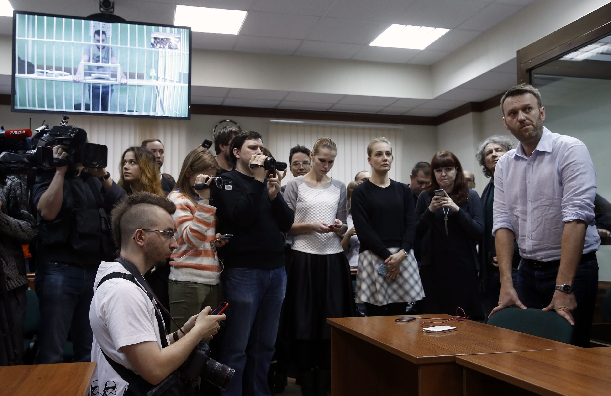 epa08983789 (FILE) - Anti-corruption blogger and liberal opposition leader Alexei Navalny (R) and his jailed brother Oleg, screened from a prison await to a verdict in a court room of the Moscow City Court in Moscow, Russia, 17 February 2015 (reissued 03 February 2021). Navalny was sentenced to 3.5 years in a penal colony for the violation of probation terms of a suspended sentence he had received for a 2014 money laundering case.  EPA/SERGEI CHIRIKOV *** Local Caption *** 51803359