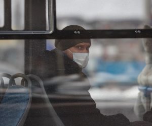 epa08996557 A Russian man wearing a protective face mask sits in a bus in Moscow, Russia, 08 February 2021, during the pandemic of SARS-CoV-2 coronavirus.  EPA/YURI KOCHETKOV