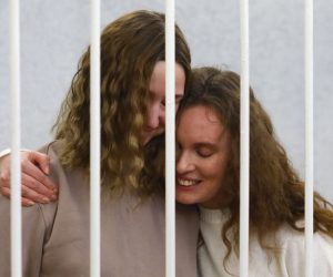 epa08998118 Belsat journalists Katerina Bakhvalova (R) (Andreeva) and Daria Chultsova (L), embrace each other in a cage before the start of a trial in Minsk, Belarus, 09 February 2021. Both journalists were detained in November 2020, when they were reporting on anti-government protests. They face up to three years in prison on charges of organizing and preparing actions that grossly violate public order.  EPA/STRINGER