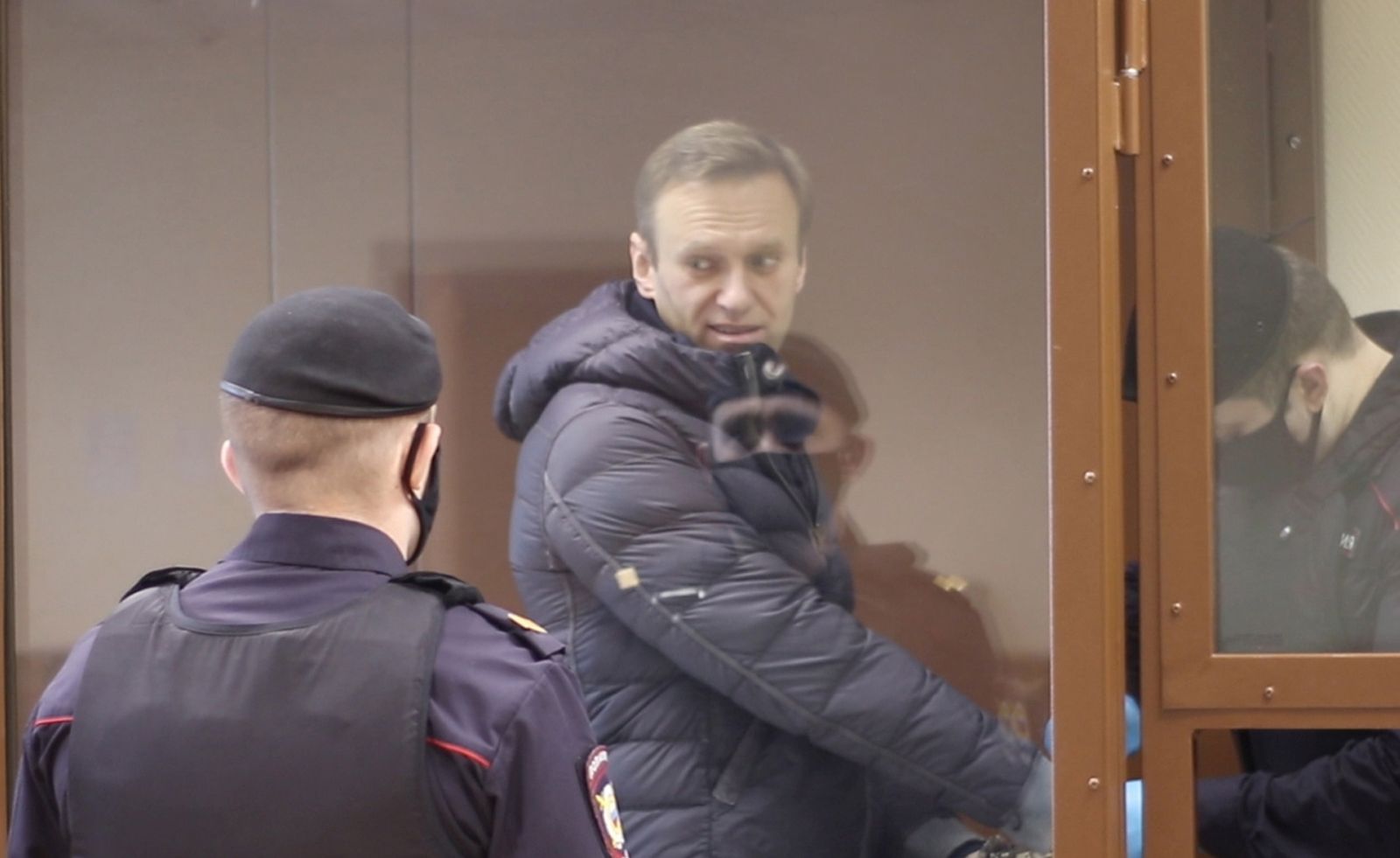 epa09015497 A still image taken from a handout video footage made available by the press service of the Babushkinsky district court shows Russian opposition leader Alexei Navalny (2-L) inside a glass cage prior to a hearing of a case on slander charges in Moscow, Russia, 16 February 2021. In June 2020 the Russian Investigative Committee opened a criminal case against Alexei Navalny on charges of slander against WWII veteran Ignat Artemenko after Navalny's comment about a video promoting the amendments to the Russian Constitution.  EPA/BABUSHKINSKY DISTRICT COURT PRES -- MANDATORY CREDIT -- BEST QUALITY AVAILABLE -- HANDOUT EDITORIAL USE ONLY/NO SALES