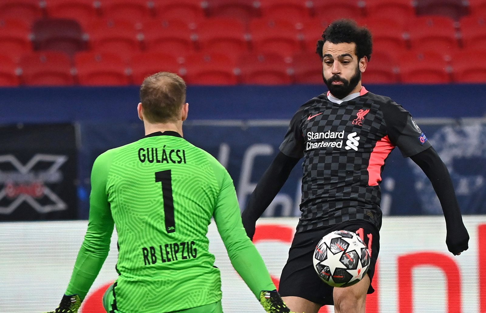 epa09017048 Hungarian goalkeeper Peter Gulacsi (L) of RB Leipzig in action against Mohamed Salah of FC Liverpool during the UEFA Champions League round of 16, first leg, soccer match between RB Leipzig and Liverpool in the Puskas Ferenc Arena in Budapest, Hungary, 16 February 2021.  EPA/TIBOR ILLYES HUNGARY OUT