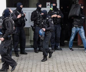 epa09035186 Policemen leave a residential building at Maerkisches Viertel city district during a police operation in Berlin, Germany, 25 February 2021. According to police, police forces from Berlin and Brandenburg undertake a large-scale raid on Islamist supporters since early this morning. The searches are related to the ban of the Jihad-Salafist organisation Jama'atu Berlin alias Tauhid Berlin by the Berlin Senate Department for the Interior and Sport.  EPA/CLEMENS BILAN
