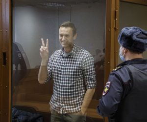epaselect epa09025242 Russian opposition leader Alexei Navalny gestures inside a glass cage prior to a hearing at the Babushkinsky District Court in Moscow, Russia, 20 February 2021. The Moscow City court will hold a visiting session at the Babushkinsky District Court Building to consider Navalny's lawyers appeal against a court verdict issued on 02 February 2021, to replace the suspended sentence issued to Navalny in the Yves Rocher embezzlement case with an actual term in a penal colony.  EPA/YURI KOCHETKOV MANDATORY CREDIT