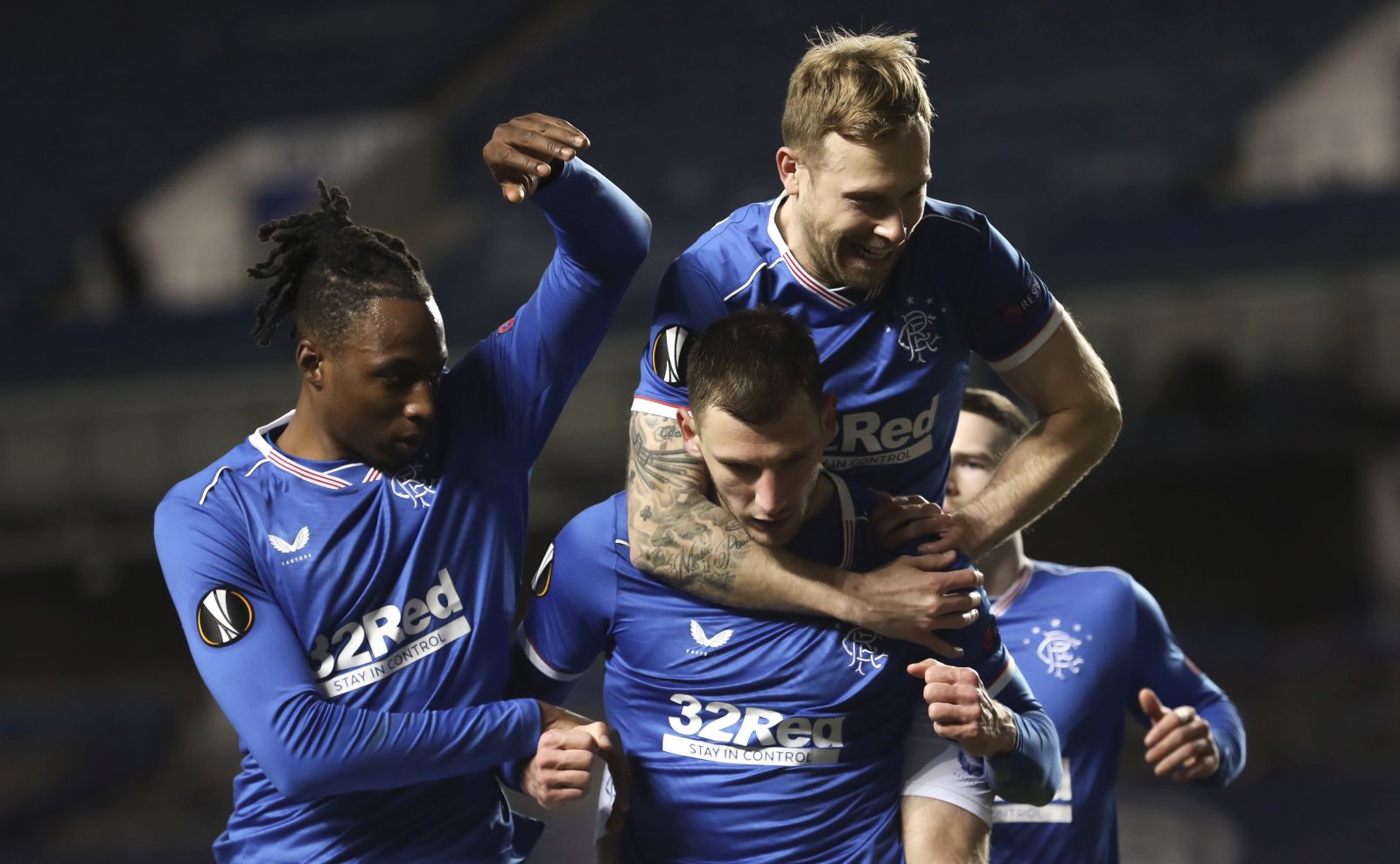 epa09036557 Borna Barisic (C) of Rangers celebrates with teammates after scoring the 4-2 lead from the penalty spot during the UEFA Europa League round of 32, second leg soccer match between Glasgow Rangers and Royal Antwerp FC in London, Britain, 25 February 2021.  EPA/Ian McNicol / POOL