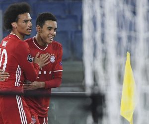 epa09032655 Bayern’s Jamal Musiala (R) celebrates with  teammate Leroy Sane (L) after scoring the 0-2 goal during UEFA Champions League round of 16 first leg soccer match between SS Lazio and Bayern Munich at Stadio Olimpico in Rome, Italy, 23 February 2021.  EPA/MAURIZIO BRAMBATTI