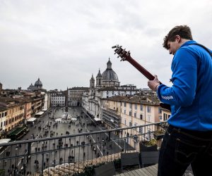 epa09059961 Guitarist Jacopo Mastrangelo plays from a terrace for the people on Piazza Navona in Rome, Italy, 07 March 2021.  EPA/ANGELO CARCONI