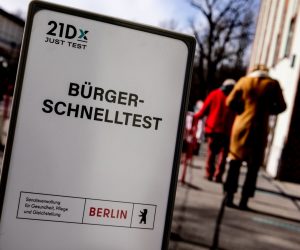 epa09063541 A sign reads in German 'Citizens' Rapid Test' as people queue at the entrance of a coronavirus COVID-19 rapid test center in Berlin, Germany, 09 March 2021. From 08 March, the German federal government will finance one rapid test per week for every citizen. The test is covered by German health insurence.  EPA/FILIP SINGER