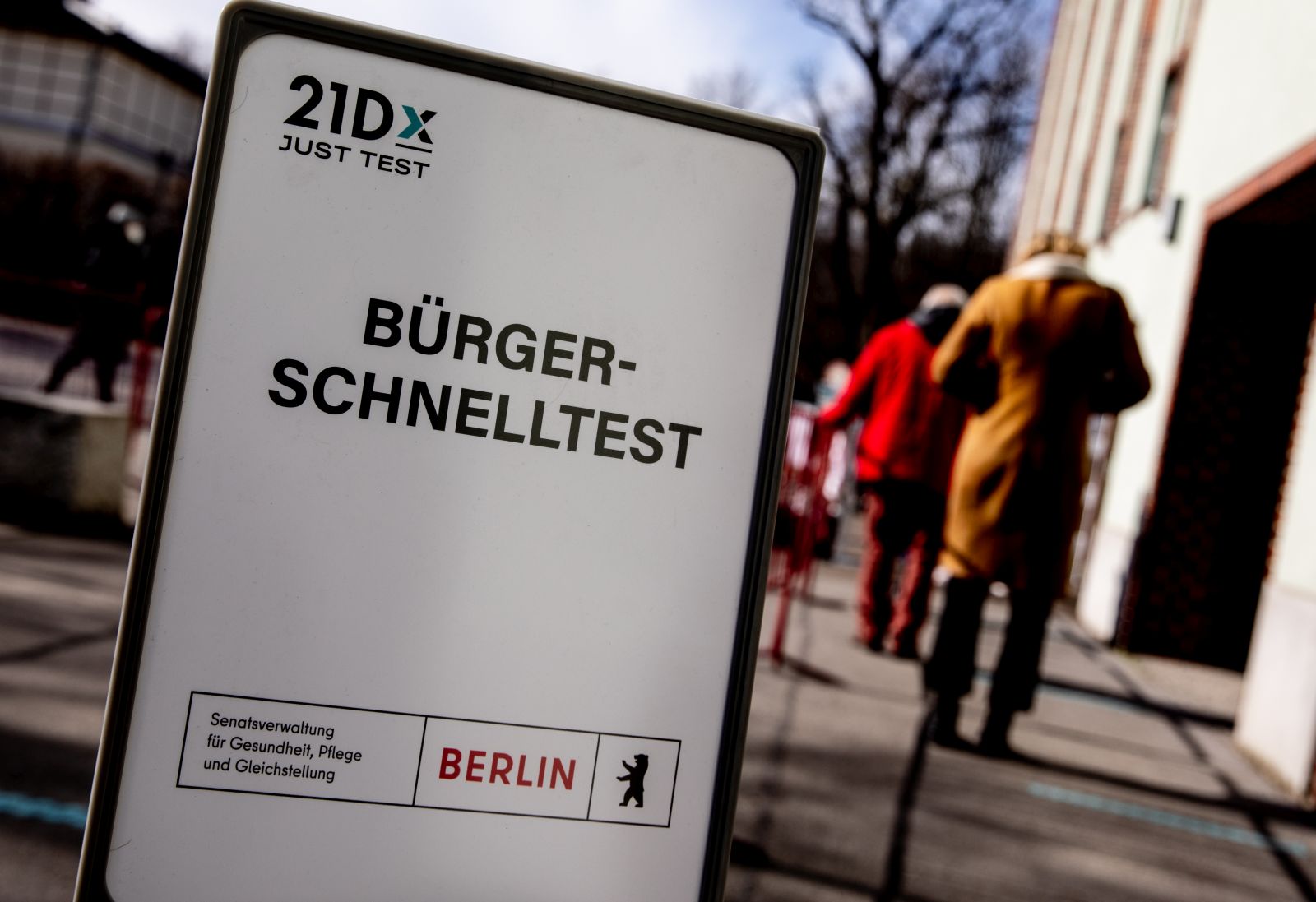 epa09063541 A sign reads in German 'Citizens' Rapid Test' as people queue at the entrance of a coronavirus COVID-19 rapid test center in Berlin, Germany, 09 March 2021. From 08 March, the German federal government will finance one rapid test per week for every citizen. The test is covered by German health insurence.  EPA/FILIP SINGER