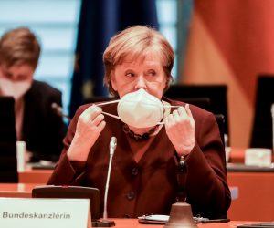 epa09064885 German Chancellor Angela Merkel puts off her face mask as she attends the weekly meeting of the German Federal cabinet in the conference hall of the Chancellery in Berlin, Germany, 10 March 2021.  EPA/FILIP SINGER / POOL