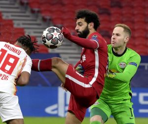 epa09066459 Christopher Nkunku (L) and goalkeeper Peter Gulacsi (R) of RB Leipzig fight for the ball with Mohamed Salah (C) of Liverpool during the UEFA Champions League round of 16, second leg, soccer match between Liverpool FC and RB Leipzig at Puskas Ferenc Arena in Budapest, Hungary, 10 March 2021  EPA/Szilard Koszticsak HUNGARY OUT
