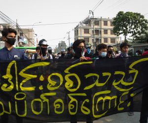 epa09084864 Demonstrators march carrying a banner that says 'Peackock Soldiers Strike' during a protest against the military coup in Mandalay, Myanmar, 20 March 2021. Anti-coup protests continued despite the intensifying violent crackdowns on demonstrators by security forces.  EPA/STRINGER