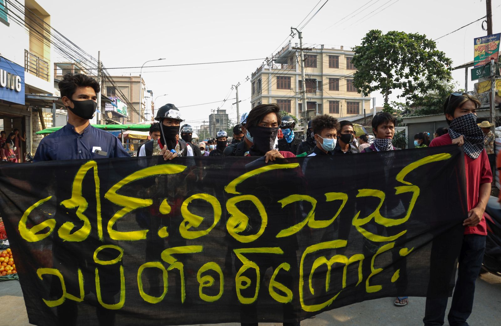 epa09084864 Demonstrators march carrying a banner that says 'Peackock Soldiers Strike' during a protest against the military coup in Mandalay, Myanmar, 20 March 2021. Anti-coup protests continued despite the intensifying violent crackdowns on demonstrators by security forces.  EPA/STRINGER