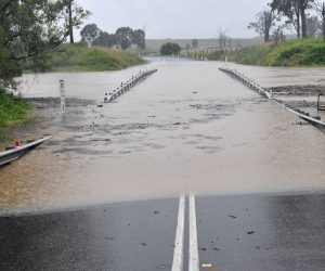 epa09090923 A bridge is submerged under flood waters at Jimboomba, near Brisbane, Australia, 23 March 2021. The weather bureau is warning of potentially life-threatening conditions from torrential rain and storms in southern Queensland.  EPA/DARREN ENGLAND AUSTRALIA AND NEW ZEALAND OUT