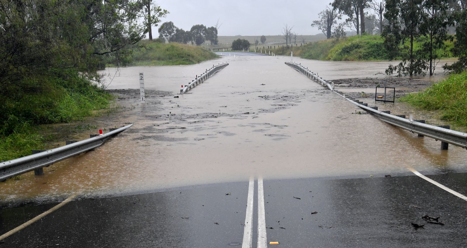 epa09090923 A bridge is submerged under flood waters at Jimboomba, near Brisbane, Australia, 23 March 2021. The weather bureau is warning of potentially life-threatening conditions from torrential rain and storms in southern Queensland.  EPA/DARREN ENGLAND AUSTRALIA AND NEW ZEALAND OUT