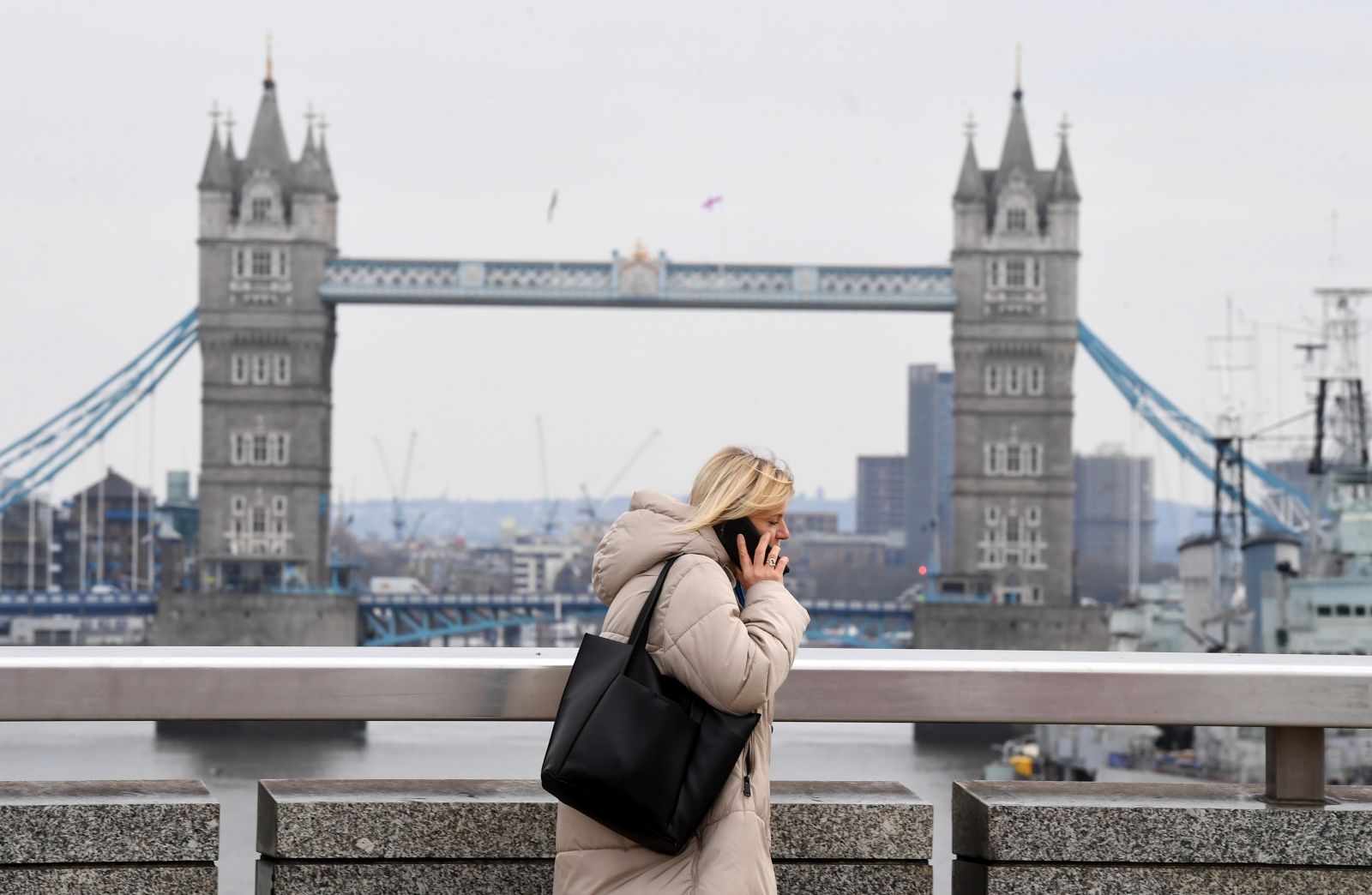 epa09091798 Pedestrians walk in London Bridge by the river Thames one year on since the lockdown began in London, Britain, 23 March 2021. A minute of silence was observed across the UK to mark a year since lockdown restrictions over the coronavirus pandemic began.  EPA/FACUNDO ARRIZABALAGA