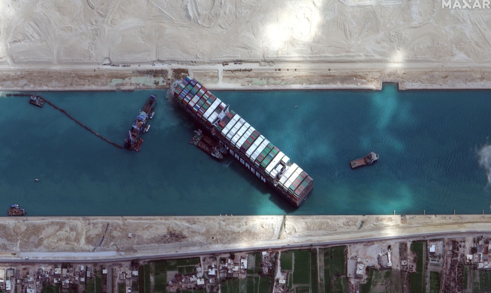 epa09103099 A handout satellite image made available by MAXAR Technologies shows excavation around the bow of the 'Ever Given' and dredging operations in progress, in the Suez Canal, Egypt, 28 March 2021. The large container ship Ever Given ran aground in the Suez Canal on 23 March, blocking passage of other ships and causing a traffic jam for cargo vessels.  EPA/MAXAR TECHNOLOGIES HANDOUT MANDATORY CREDIT: SATELLITE IMAGE 2020 MAXAR TECHNOLOGIES -- the watermark may not be removed/cropped -- HANDOUT EDITORIAL USE ONLY/NO SALES