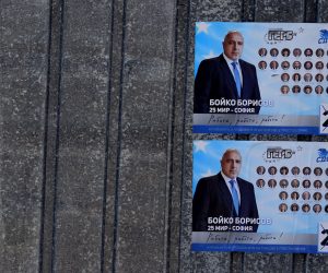 epa09108200 A man with a bicycle passes in front of campaign posters of Bulgaria's centre-right ruling GERB party with pictures of Bulgarian Prime minister Boyko Borissov in Bankaj, Bulgaria, 31 March 2021. Bulgaria will hold parliamentary elections on 04 April 2021.  EPA/VASSIL DONEV