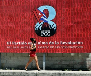 epa09132926 A woman walks in front of a banner that promotes the VIII Congress of the Communist Party of Cuba (PCC), to be held from 16 April to 19 April in Havana, Cuba, 13 April 2021. The generational change with the withdrawal of Raul Castro, the serious economic crisis and the loss of the hegemony of discourse due to the irruption of the internet are some of the challenges that the Cuban communists will face at this summit.  EPA/Ernesto Mastrascusa