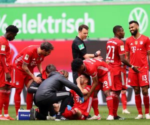 epa09141780 Lucas Hernandez of FC Bayern Muenchen receives medical treatment as teammate Kingsley Coman checks on him during the German Bundesliga soccer match between VfL Wolfsburg and FC Bayern Munich at Volkswagen Arena in Wolfsburg, Germany, 17 April 2021.  EPA/MARTIN ROSE / POOL DFL regulations prohibit any use of photographs as image sequences and/or quasi-video.
