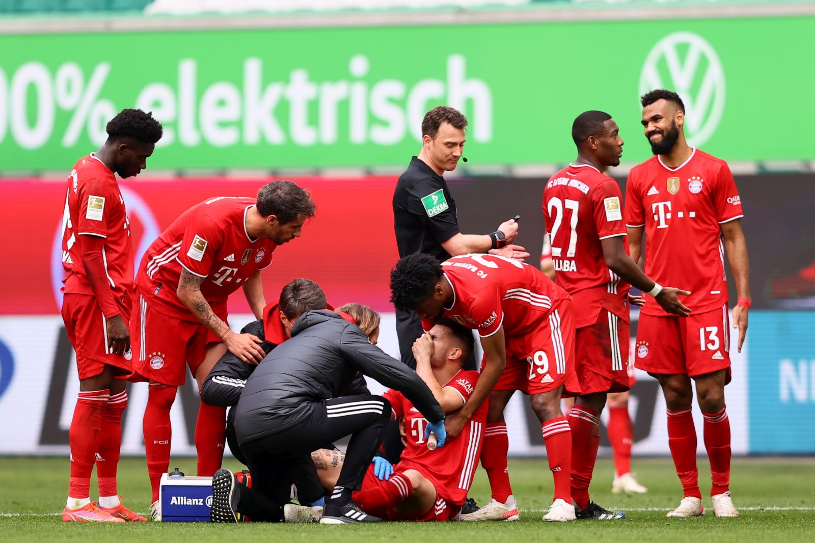 epa09141780 Lucas Hernandez of FC Bayern Muenchen receives medical treatment as teammate Kingsley Coman checks on him during the German Bundesliga soccer match between VfL Wolfsburg and FC Bayern Munich at Volkswagen Arena in Wolfsburg, Germany, 17 April 2021.  EPA/MARTIN ROSE / POOL DFL regulations prohibit any use of photographs as image sequences and/or quasi-video.