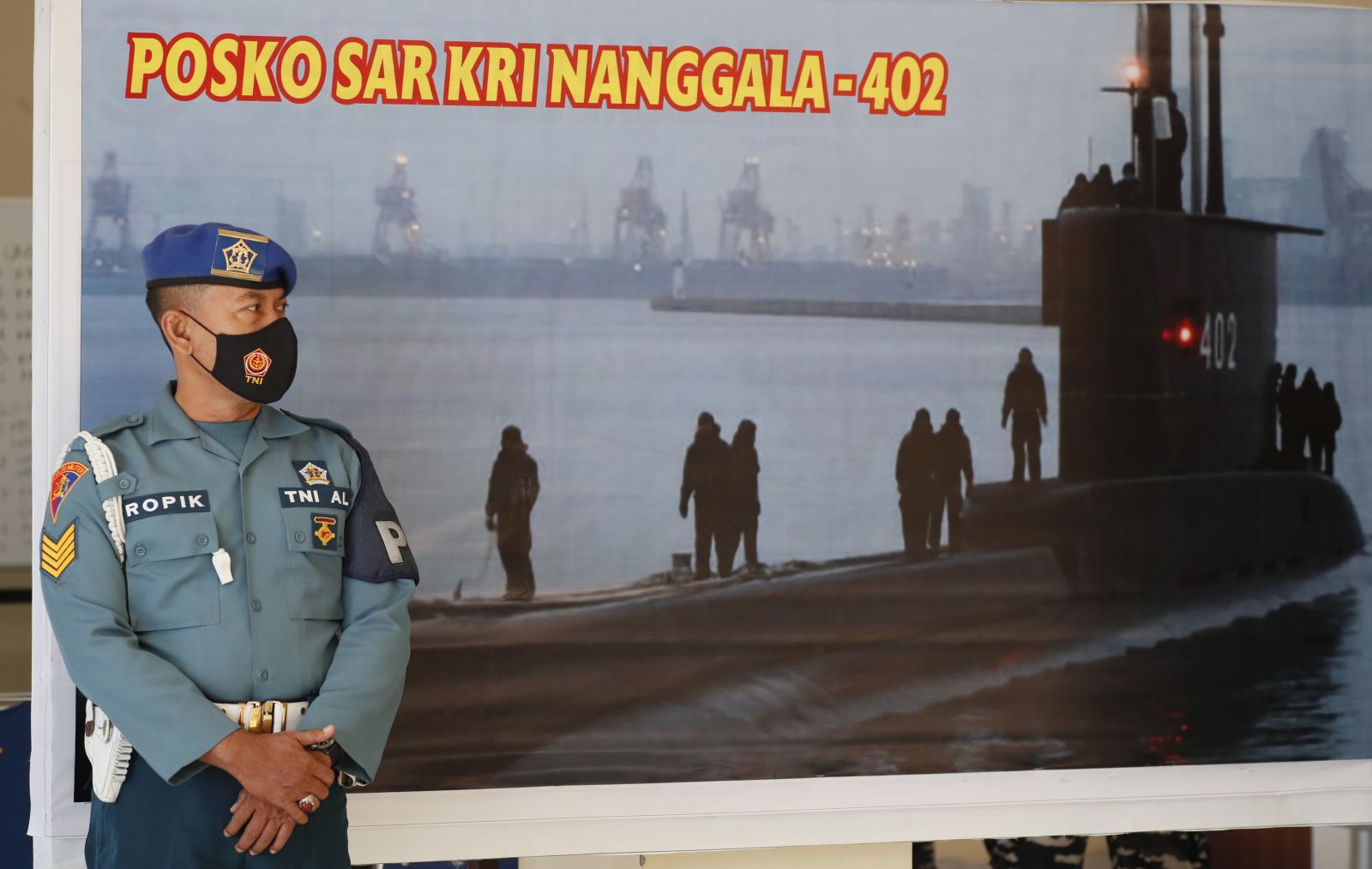 epa09154443 A military officer stands in front a search and rescue command for the missing Indonesian Navy submarine KRI Nanggala, at Ngurah Rai Airport in Bali, Indonesia, 23 April 2021. The German-made submarine was reported missing on 21 April 2021 near the island of Bali with 53 people on board while preparing to conduct a torpedo drill, the the Indonesian National Armed Forces said.  EPA/MADE NAGI