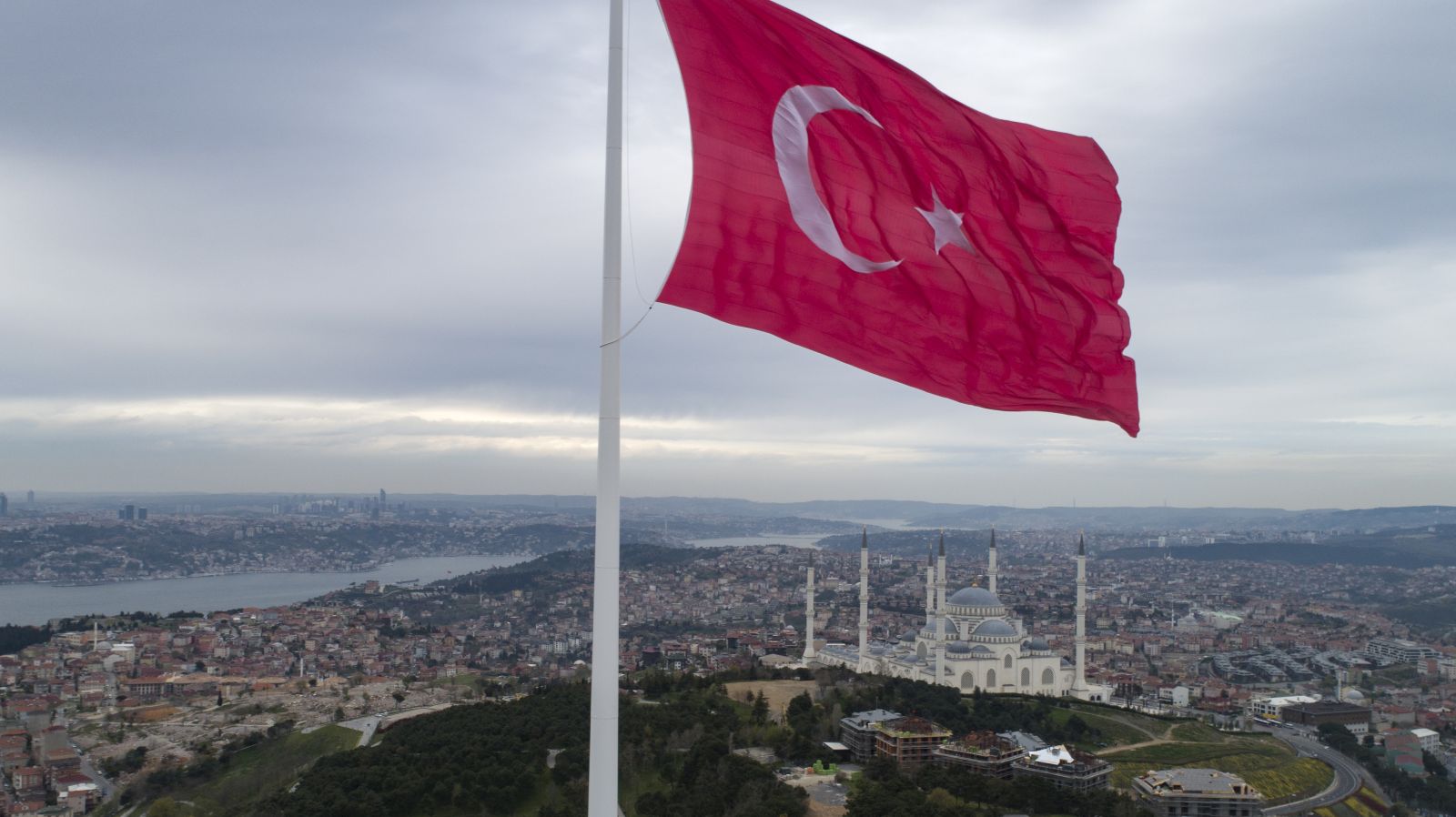 epa09155224 An aerial picture taken with a drone shows a huge Turkish flag fluttering at the Camlica Hill in Istanbul, Turkey, 23 April 2021. A 111-meter-long (364 feet) and 1,000-square-meter (107,639-square-foot) wide Turkey's tallest flag was inaugurated on Istanbul’s Camlıca Hill as Turkish President Recep Tayyip Erdogan attended with a group of children during the occasion of National Sovereignty and Children’s Day.  EPA/ERDEM SAHIN