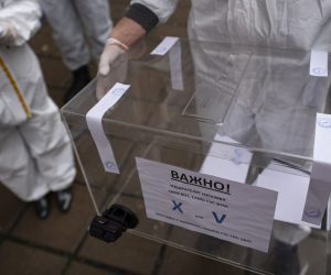 epa09114919 A staff member of a mobile polling station wearing a protective suits holds a mobile ballot box at Pirogov Hospital in Sofia, Bulgaria, 04 April 2021. Bulgaria is holding a parliamentary election on 04 April amid a surge in coronavirus COVID-19 cases. Despite criticisms, the GERB party led by incumbent Prime Minister Boyko Borissov is leading the polls and is expected to win another four-year term.  EPA/VASSIL DONEV