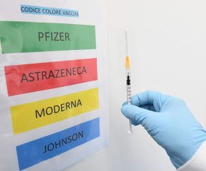 epa09170062 A medical staff holds a syringe next to a color code sign listing the Covid-19 vaccines BioNTech/Pfizer, AstraZeneca, Moderna and Johnson&Johnson at the Covid-19 vaccination hub set up in Novegro, near Milan, Italy, 30 April 2021.  EPA/Daniel Dal Zennaro
