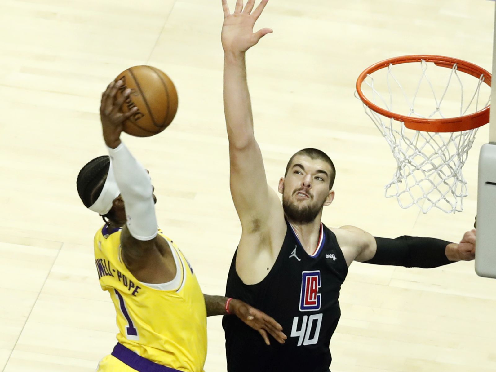 epa09182195 Los Angeles Lakers guard Kentavious Caldwell-Pope (L) scores against Los Angeles Clippers center Ivica Zubac (R) during the first quarter of the NBA basketball game between the Los Angeles Lakers and the Los Angeles Clippers at the Staples Center in Los Angeles, California, USA, 06 May 2021.  EPA/ETIENNE LAURENT SHUTTERSTOCK OUT