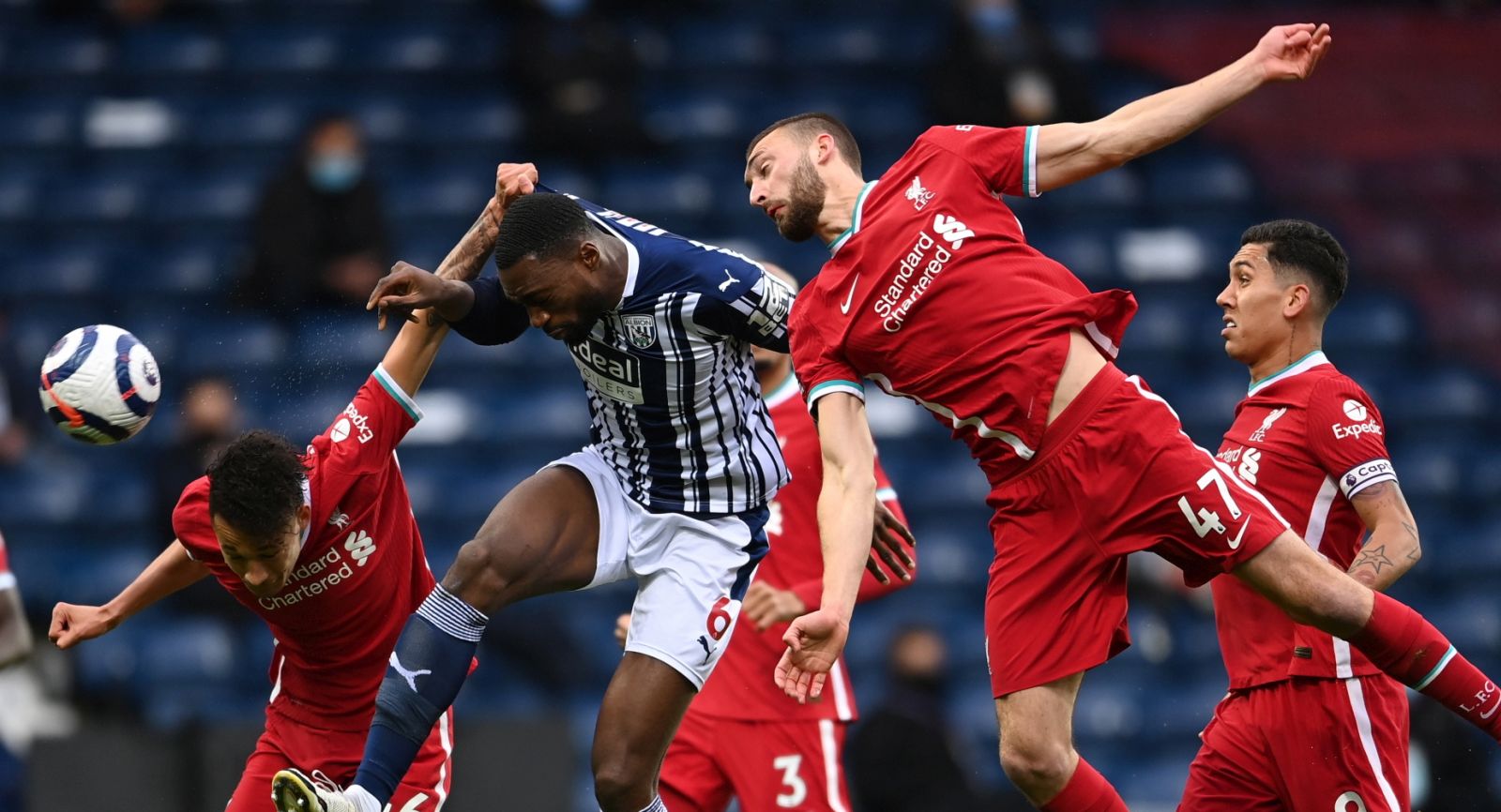 epa09204613 Semi Ajayi (C) of West Bromwich in action against Rhys Williams (L) and Nathaniel Phillips (R) of Liverpool during the English Premier League soccer match between West Bromwich Albion and Liverpool FC in West Bromwich, Britain, 16 May 2021.  EPA/Laurence Griffiths / POOL EDITORIAL USE ONLY. No use with unauthorized audio, video, data, fixture lists, club/league logos or 'live' services. Online in-match use limited to 120 images, no video emulation. No use in betting, games or single club/league/player publications.