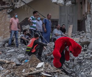 epa09205338 A Palestinian holds a teddy bear from the rubble of a destroyed houses after an Israeli air strike in Gaza City on, 16 May 2021. Thirteen Palestinian were killed and more than 40 others wounded after Israeli air strike in Gaza. In response to days of violent confrontations between Israeli security forces and Palestinians in Jerusalem, various Palestinian militants factions in Gaza launched rocket attacks since 10 May that killed at least six Israelis to date. Gaza Strip's health ministry said that at least 65 Palestinians, including 13 children, were killed in the recent retaliatory Israeli airstrikes. Hamas confirmed the death of Bassem Issa, its Gaza City commander, during an airstrike.  EPA/MOHAMMED SABER