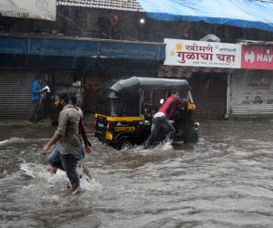epa09207304 Indian people wade through flooded street during heavy rainfall after cyclone Tauktae hits Mumbai and nearby areas, India, 17 May 2021. According to the India Meteorological Department (IMD) forecast, Cyclone Tauktae will make a landfall over the Gujarat coastal area, including Kerala, Karnataka, Maharashtra and Goa with a wind speed of around 150 kmph.  EPA/STR