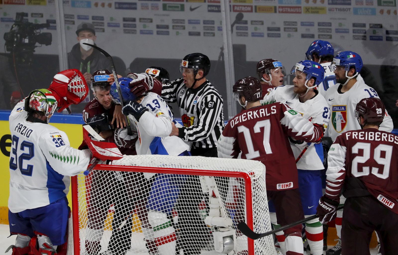 epa09225294 Players of Latvia (red) and players of Italy (white) in action during the IIHF 2021 World Ice Hockey Championships group B match between Latvia and Italy at the Arena Riga, Latvia, 24 May 2021.  EPA/TOMS KALNINS
