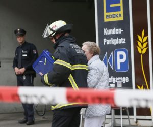 An elderly woman is accompanied by a firefighter after a knife attack at a supermarket in Hamburg, Germany, 28 July 2017. A man killed another person and injured several during a supermarket robbery in the district of Barmbek in Hamburg on 28 July. The suspect was arrested, the police informed on Twitter. Photo: Paul Weidenbaum/dpa