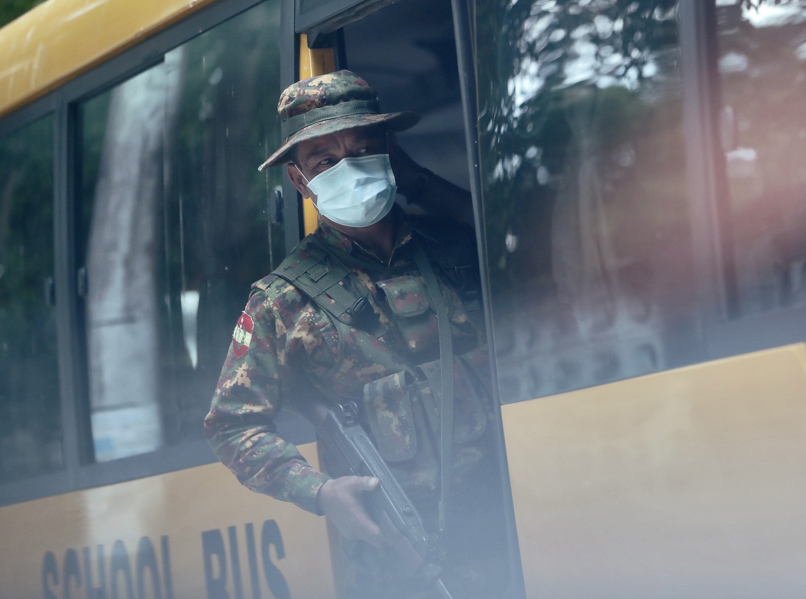 epaselect epa09240353 Soldiers board a school bus outside a high school in Yangon, Myanmar, 01 June 2021. Schools in Myanmar open for the new school year even after the military suspended thousands of teachers for joining a civil disobedience movement protesting the 01 February military coup.  EPA/STRINGER