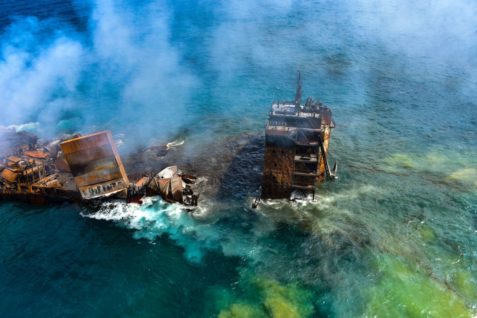 epa09243157 A handout photo made available by the Sri Lankan Air force Media shows the fire gutted and crippled Singapore-registered container cargo vessel, MV X-Press Pearl, on the 9 nautical miles northwest of Colombo port in Colombo, Sri Lanka, 02 June 2021. The fire on the Singaporean flagged container cargo vessel MV X-Press Pearl, which had been burning for over 13 days, was doused and the salvage company began towing it towards deeper seas off the coast of Colombo on 02 June. However, latest reports by the Sri Lanka Navy stated that the towing operation had been halted as the stern of the ship was striking the seabed. They also reported that so far no oil spills have been observed. A huge amount of plastic granules and debris has already washed ashore on beaches from Colombo to Negombo and authorities now fear another wave of massive pollution should the 278 tonnes of bunker oil and 50 tonnes of gas in the Singapore-registered ship's fuel tanks leak into the Indian Ocean.  EPA/SRI LANKAN AIR FORCE MEDIA HANDOUT  HANDOUT EDITORIAL USE ONLY/NO SALES
