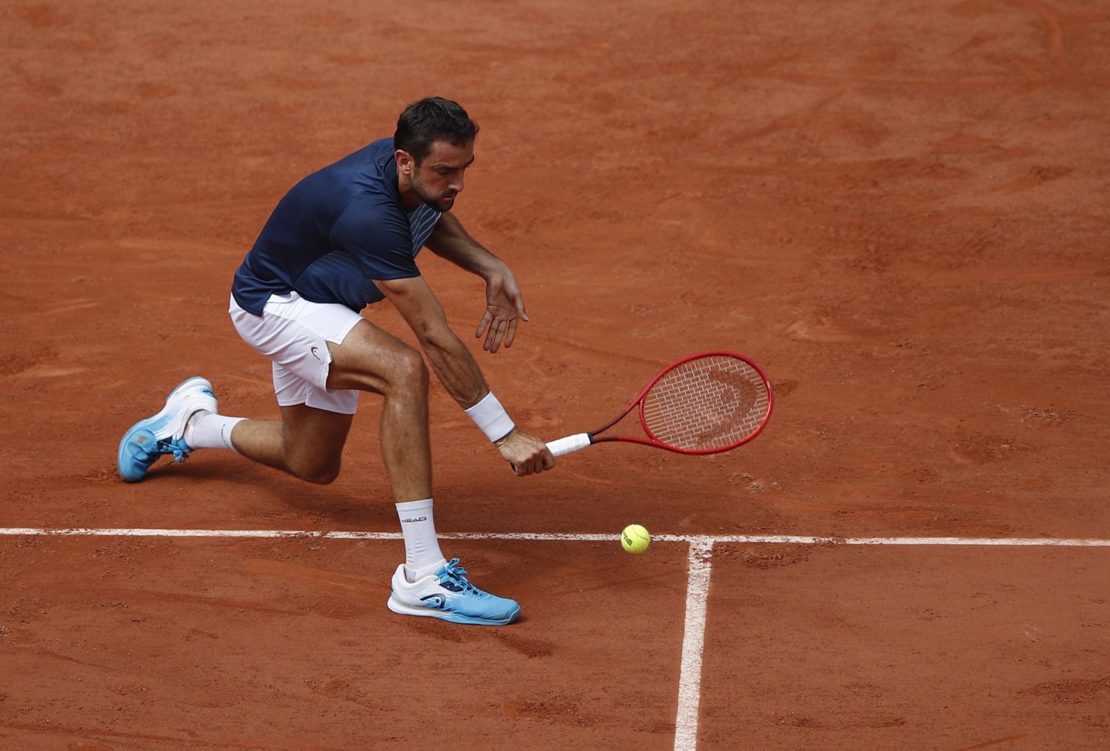 epa09245381 Marin Cilic of Croatia in action against Roger Federer of Switzerland during their second round match at the French Open tennis tournament at Roland Garros in Paris, France, 03 June 2021.  EPA/YOAN VALAT
