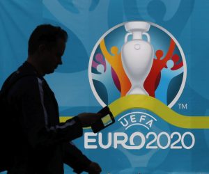 epa09251609 A man walks past a poster with the UEFA EURO 2020 logo ahead of the UEFA EURO 2020 soccer tournament in St.Petersburg, Russia, 06 June 2021. The European Championship, which was delayed from last year due to the Coronavirus pandemic features seven matches in St. Petersburg.  EPA/ANATOLY MALTSEV