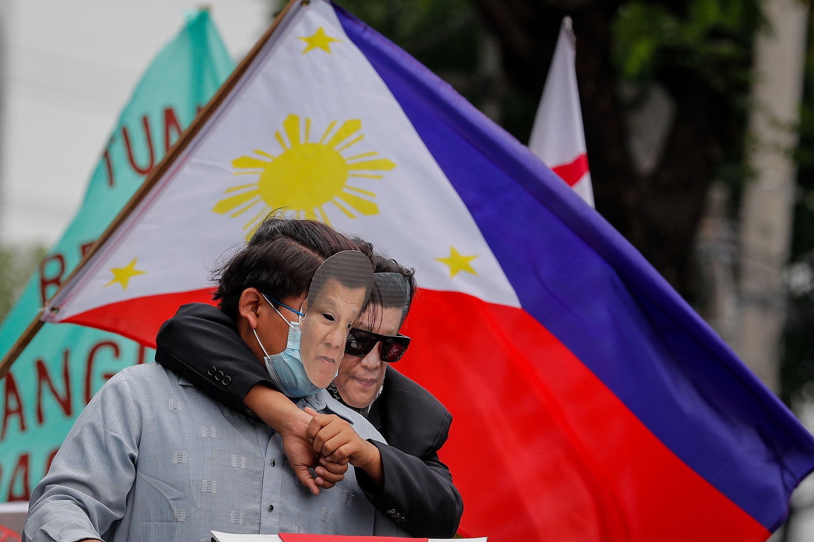 epa09263839 Demonstrators dressed as Chinese President Xi Jinping (R) and Philippines President Rodrigo Duterte (L) pose for pictures during a protest to mark the 123rd Independence Day at the Chinese Consulate in Makati, Metro Manila, Philippines, 12 June 2021. Various militant groups held a demonstration at the Chinese Consulate to denounce China's continued presence and activities inside Philippine territory in the disputed South China sea.  EPA/MARK R. CRISTINO