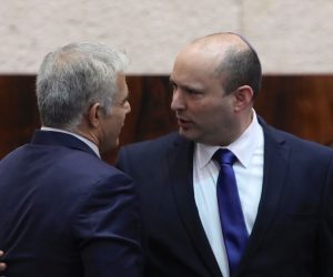epa09267664 Leader of the Yemina party and designated prime minister Naftali Bennett  (R) embraces his political partner Yair Lapid (L) during a special voting session on the formation of a new coalition government at the Knesset Plenum, at the Knesset, Israeli parliament, in Jerusalem, Israel, 13 June 2021.The Knesset is convening for a vote that is expected to end the historic 12-year rule of Prime Minister Benjamin Netanyahu.  EPA/ABIR SULTAN