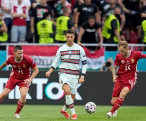 epa09273887 Cristiano Ronaldo (C) of Portugal in action against Endre Botka (L) and Gergo Lovrencsics of Hungary during the UEFA EURO 2020 group F preliminary round soccer match between Hungary and Portugal in Budapest, Hungary, 15 June 2021.  EPA/HUGO DELGADO